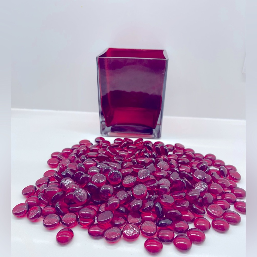 Red pebbles in a red romantic square glass vase.